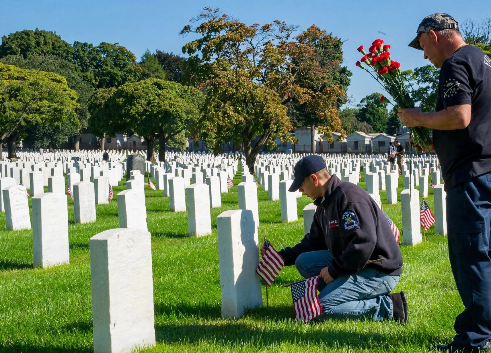 Volunteers placing flags at headstones in a national cemetery
